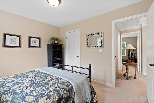 bedroom with attic access, visible vents, light carpet, and baseboards