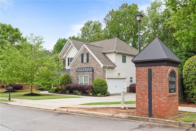 traditional home with driveway, a shingled roof, brick siding, and a garage