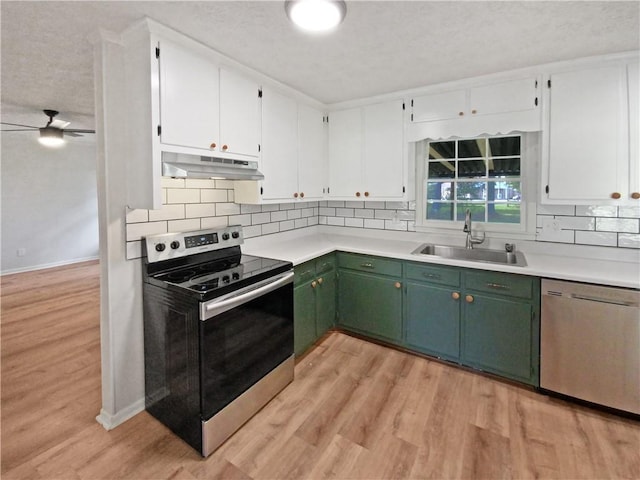 kitchen with appliances with stainless steel finishes, light hardwood / wood-style flooring, ceiling fan, sink, and green cabinets