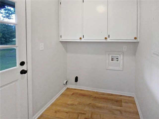 washroom with light hardwood / wood-style floors, washer hookup, and cabinets