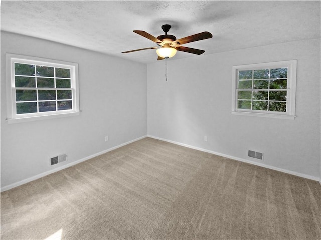 unfurnished room featuring ceiling fan, plenty of natural light, and carpet floors