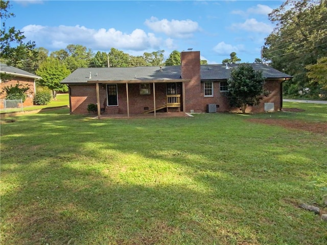 rear view of property with a lawn and central AC unit