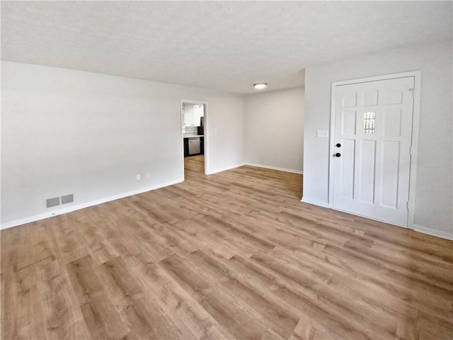 interior space with light hardwood / wood-style floors and a textured ceiling