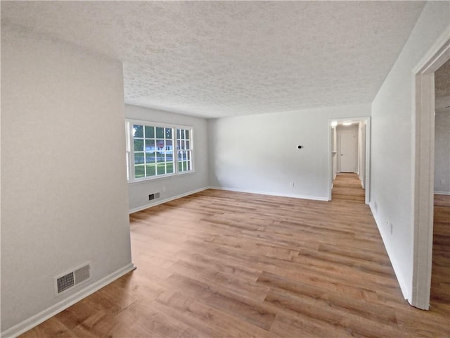 spare room with light hardwood / wood-style flooring and a textured ceiling