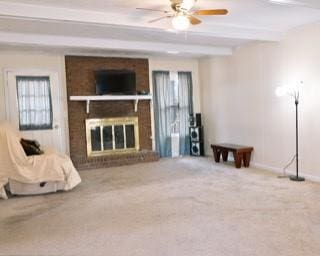 566 Sugar Valley Ln, Conyers, GA 30094 - unfurnished living room with baseboards, ceiling fan, carpet flooring, a brick fireplace, and beam ceiling