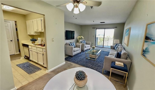 carpeted living room featuring ceiling fan and sink