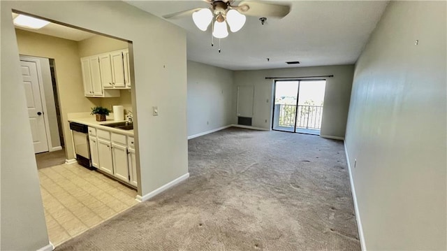 kitchen with white cabinetry, sink, ceiling fan, light colored carpet, and dishwashing machine