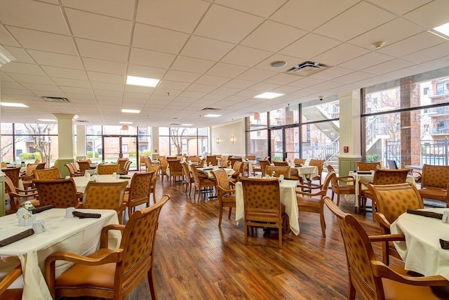 dining area with hardwood / wood-style flooring and a wall of windows