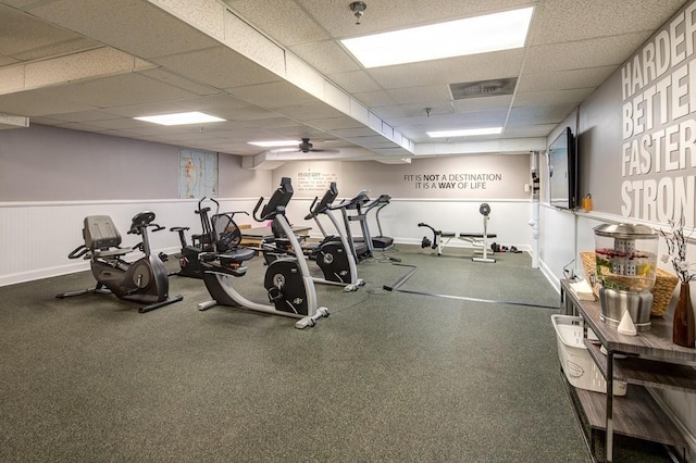 exercise room with a drop ceiling and ceiling fan