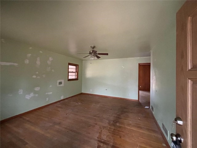 spare room with ceiling fan and dark hardwood / wood-style floors