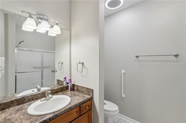 bathroom featuring toilet, a stall shower, and vanity