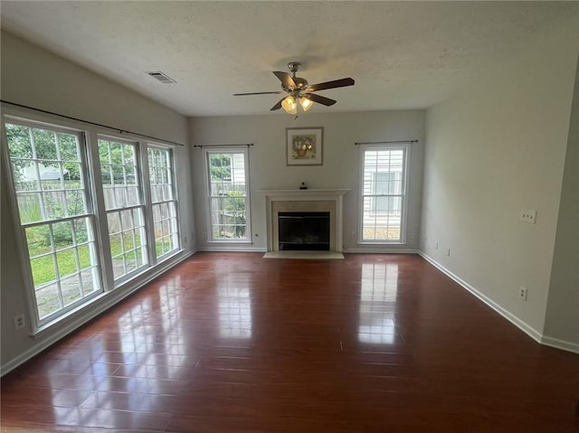 2994 Abbotts Oak Way, Duluth, GA 30097 - unfurnished living room featuring plenty of natural light, ceiling fan, a glass covered fireplace, wood finished floors, and a textured ceiling
