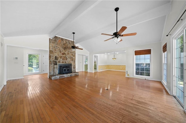 unfurnished living room featuring ceiling fan, lofted ceiling with beams, hardwood / wood-style flooring, and a fireplace