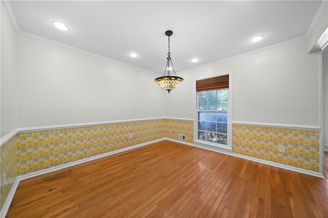 unfurnished room featuring wallpapered walls, ornamental molding, recessed lighting, wainscoting, and hardwood / wood-style floors