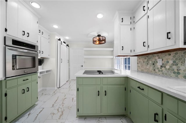 kitchen with green cabinets, a barn door, oven, decorative backsplash, and white cabinets