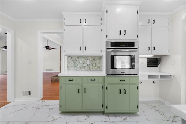 kitchen with green cabinets, ornamental molding, stainless steel oven, white cabinetry, and ceiling fan