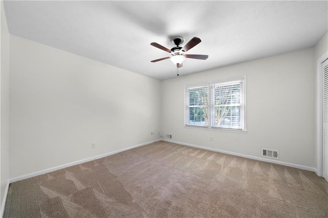 carpeted empty room with ceiling fan, baseboards, and visible vents