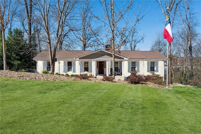 ranch-style home featuring a front lawn, a chimney, and brick siding