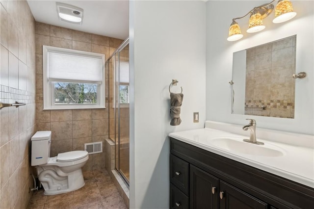 bathroom with toilet, a stall shower, tile patterned flooring, and visible vents