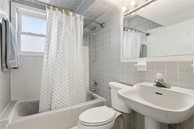 full bath featuring tile walls, tasteful backsplash, shower / bathtub combination with curtain, toilet, and a sink