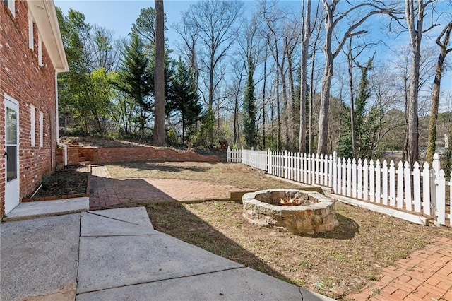 view of yard featuring a fire pit, a patio area, and fence