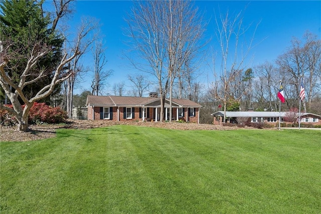 view of front of property with brick siding and a front lawn