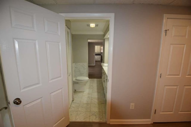 corridor featuring baseboards and ornamental molding