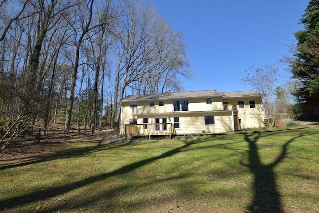 back of house featuring a lawn and a deck