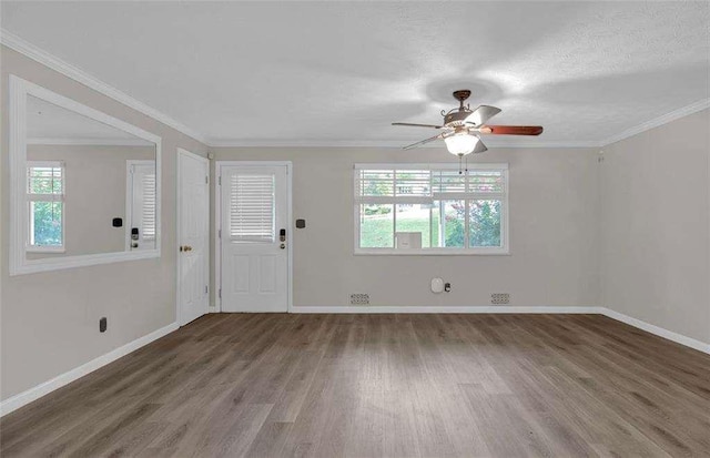 interior space featuring baseboards, a ceiling fan, wood finished floors, and crown molding