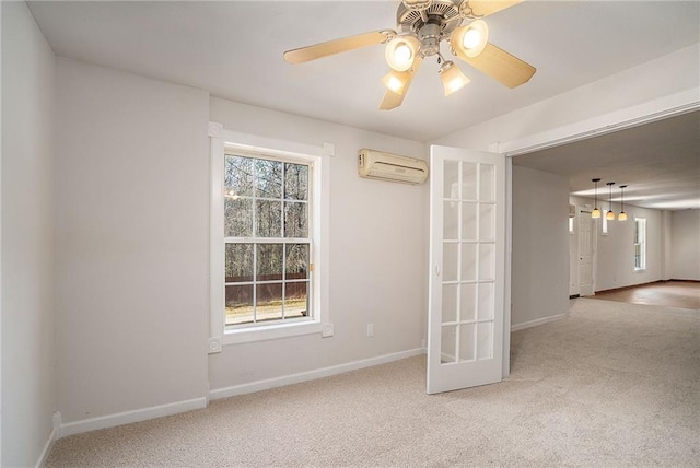 spare room featuring light carpet, french doors, a wall mounted AC, and a healthy amount of sunlight