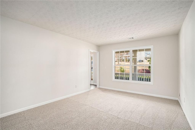 spare room with a textured ceiling and carpet floors