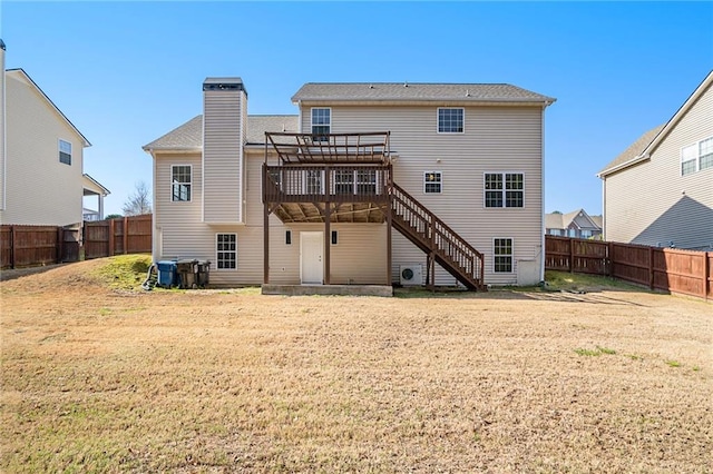 rear view of house with a yard and a wooden deck