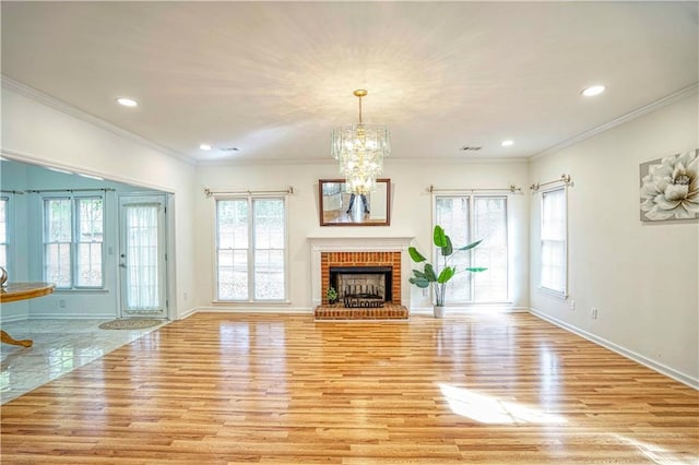 unfurnished living room with a brick fireplace, a wealth of natural light, and light wood-type flooring