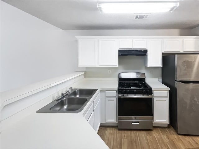 kitchen with stainless steel appliances, exhaust hood, and light countertops