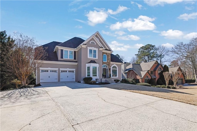 traditional-style house featuring concrete driveway and stucco siding