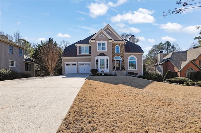 traditional-style house with concrete driveway, a front lawn, a chimney, and an attached garage