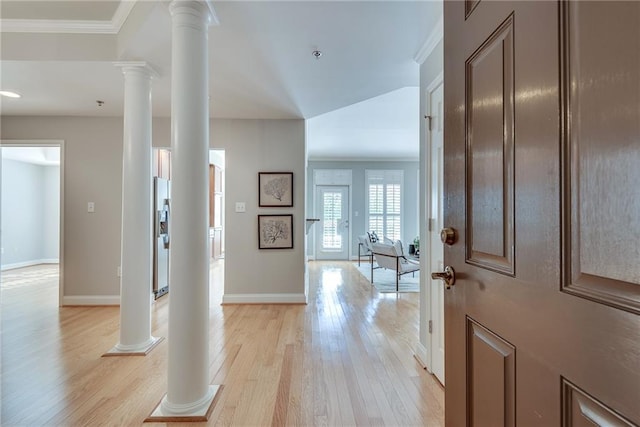 foyer with light wood-type flooring, ornamental molding, and ornate columns