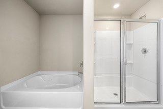 full bathroom featuring a stall shower and a bath