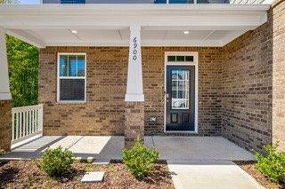 property entrance with covered porch and brick siding