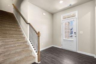 entrance foyer featuring baseboards, stairs, wood finished floors, and visible vents