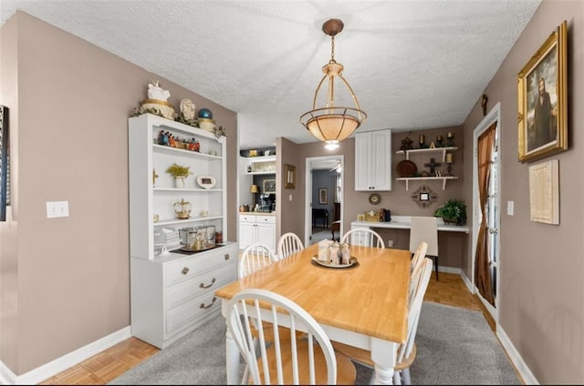 dining room featuring light parquet flooring and a textured ceiling