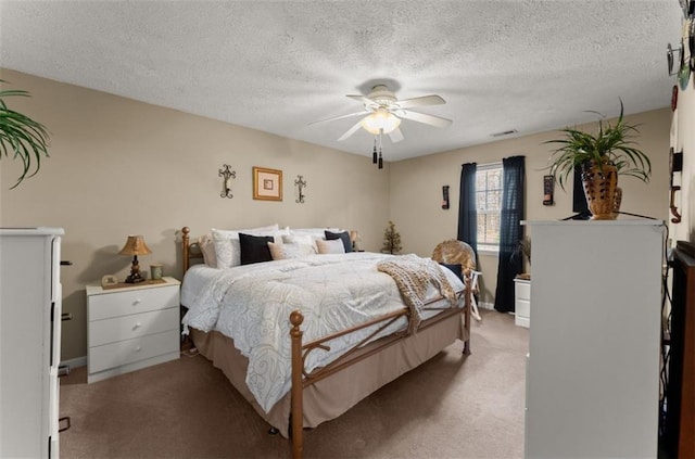 bedroom featuring ceiling fan, light colored carpet, and a textured ceiling