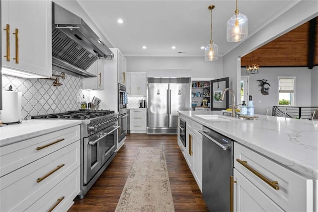 kitchen with white cabinets, sink, wall chimney exhaust hood, and high quality appliances