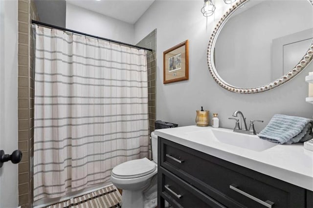 bathroom with vanity, curtained shower, and toilet