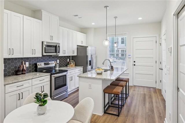 1095 Tucker Ave Unit 207, Atlanta, GA 30310 - kitchen with wood finished floors, visible vents, stainless steel appliances, and a sink