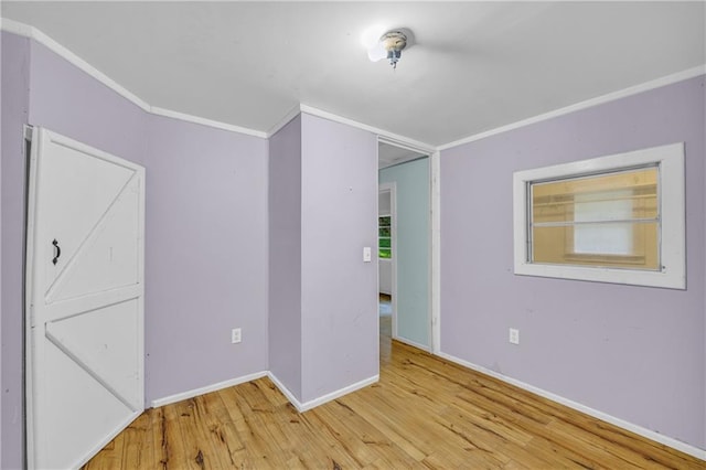 empty room with crown molding and hardwood / wood-style flooring