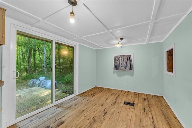 spare room with light wood-type flooring and coffered ceiling