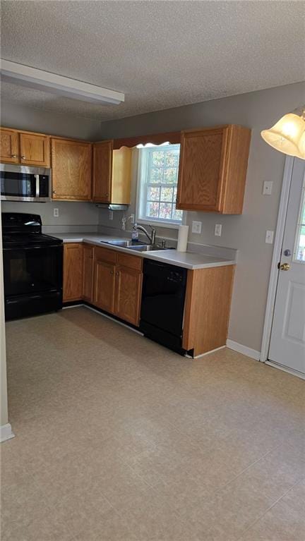 kitchen with sink, black appliances, and a textured ceiling