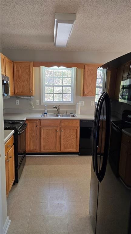 kitchen with a textured ceiling, sink, and black appliances