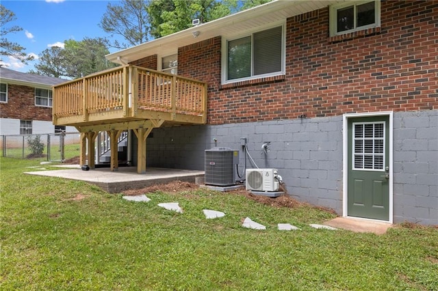 back of property featuring a wooden deck, ac unit, a yard, fence, and central AC